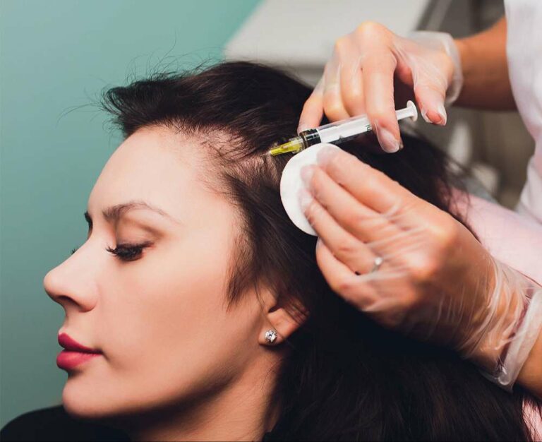 Frau bekommt Injektion in den Stirnbereich zur Haartherapie
